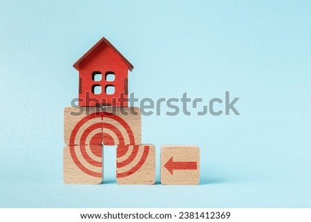 House model on wooden cubes with target symbol. Concept of the right strategy in goal setting in real estate acquisition