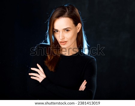 A woman with her arms crossed posing for a picture. A Confident Woman Striking a Pose for a Captivating Portrait