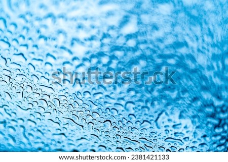 Close Up of Rainy Window with Water Droplets. A close up of a window with drops of water on it
