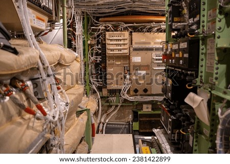 Electronic boxes and circuit breaker panels inside an electronics and equipment bay in a 787 commercial passenger airplane. Royalty-Free Stock Photo #2381422899