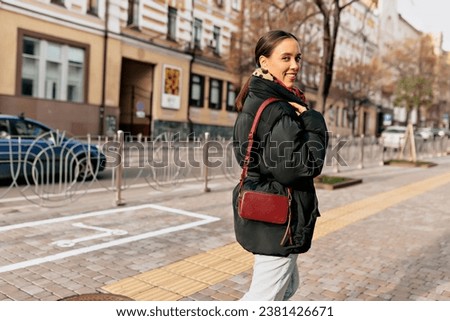  Outdoor photo of smiling girl with wonderful smile turn around to camera while walking through the city