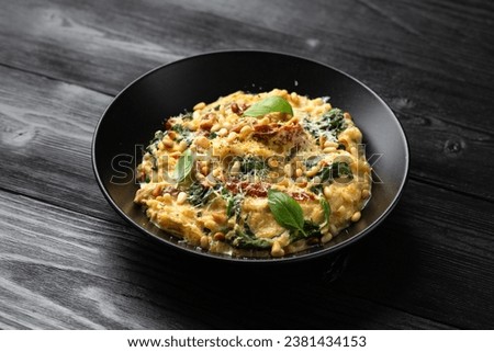 Creamy spaghetti squash pasta with parmesan cheese and sun dried tomato sauce served with pine nuts and basil. Royalty-Free Stock Photo #2381434153