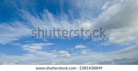 In this close-up photo, cumulus and stratus clouds dance across the sky, their shapes intricate and distinct. Cotton tufts of cumulus clouds intertwine with stratus, smooth expanses of stratus clouds Royalty-Free Stock Photo #2381438849
