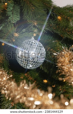 Christmas holiday festive. Disco ball christmas ornament, hanging in christmas tree. A reflection causes a glare. No people. High quality image. 