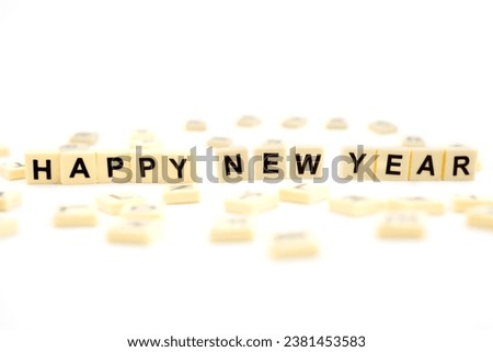 The word HAPPY NEW YEAR with wooden letter tiles isolated on white background