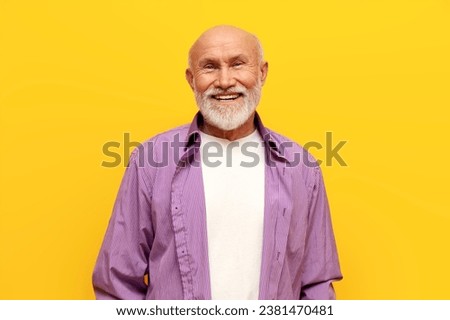 old bald grandfather with gray beard in purple shirt smiling on yellow isolated background, elderly pensioner looking at the camera Royalty-Free Stock Photo #2381470481
