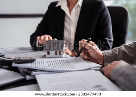 Businessman real estate seller explaining about property investment document with terms data of home sales contract and home insurance while businessman asking terms data and signing on contract.