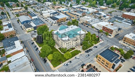 Aerial wide shot of Auburn Indiana city with focus on downtown courthouse Royalty-Free Stock Photo #2381480297