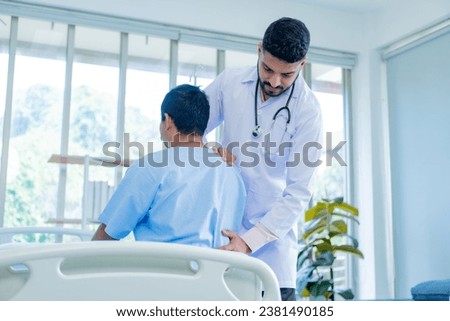 Doctor physiotherapist treating lower back pain patient after while giving exercising treatment on stretching in the hospital, Rehabilitation physiotherapy concept. Royalty-Free Stock Photo #2381490185