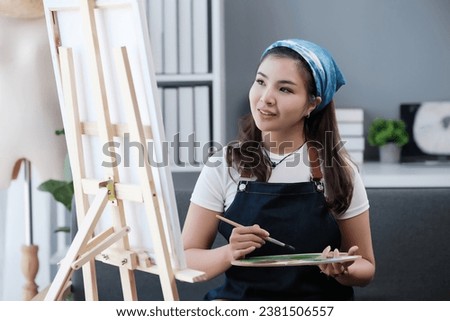 Portrait of a young asian student sitting with still life painting at the studio