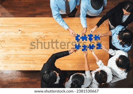 Multiethnic business people holding jigsaw pieces and merge them together as effective solution solving teamwork, shared vision and common goal combining diverse talent. Panorama top view. Meticulous Royalty-Free Stock Photo #2381530667