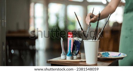 hand of artist with brush painting picture art, creativity, artistic and artwork, painting, Colorful artist brushes and paint palette concept