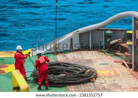 Procced loading of pennant wire, anchor buoy by ship crew to be used for anchor handling or anchor job activities Royalty-Free Stock Photo #2381552757