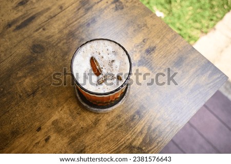 A glass of Iced Lychee Tea on Wooden Table Top View Selective Focus