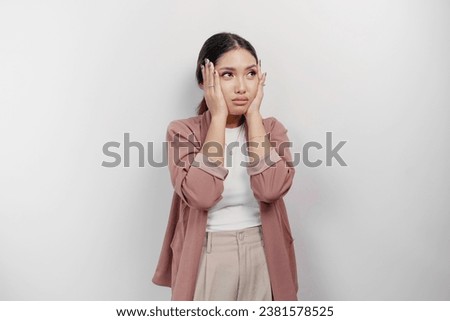 A sad Asian woman employee wears cardigan, looks stressed and depressed, isolated white background. Royalty-Free Stock Photo #2381578525