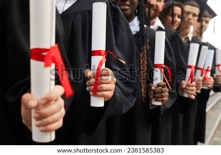University students with diplomas in hands. Group of young people holding educational certificates confirming they have obtained necessary professional qualifications. Crop closeup. Graduation concept Royalty-Free Stock Photo #2381585383