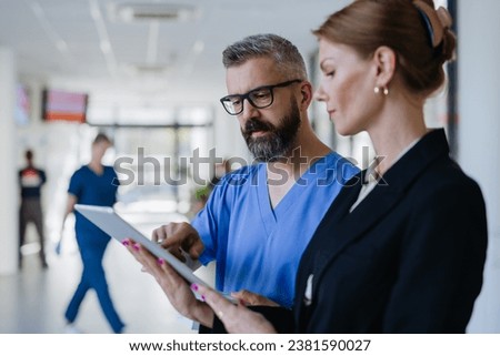 Pharmaceutical sales representative talking with doctor in medical building. Ambitious female hospital director consulting with healtcare staff. Woman business leader. Royalty-Free Stock Photo #2381590027