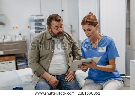 Female doctor consulting with overweight patient, discussing test result in doctor office. Obesity affecting middle-aged men's health. Concept of health risks of overwight and obesity. Royalty-Free Stock Photo #2381590061