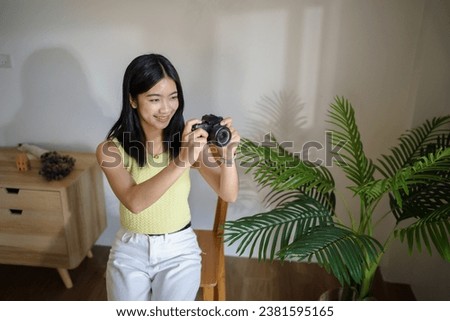 Happy young Asian Woman photographer holding camera Creative female freelancer working freelance creative artist.