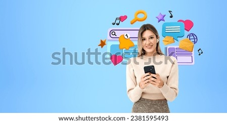 Happy young woman with phone and earbuds, looking at the camera on copy space blue background. Colorful cartoon digital world icons. Concept of social media, communication and entertainment