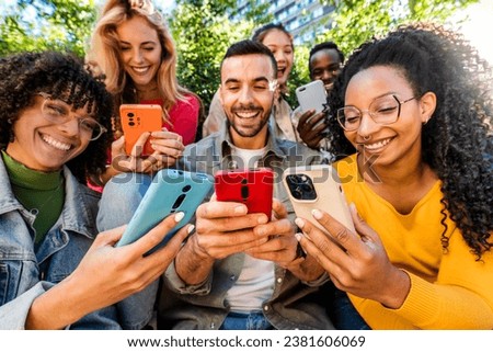 Group of young people using smart mobile phone outdoors - Happy friends with smartphone laughing together watching funny video on social media platform - Tech and modern life style concept  Royalty-Free Stock Photo #2381606069