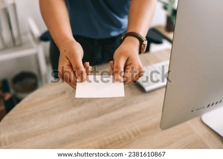 Close up of businesswoman handing a blank business card at the office desk