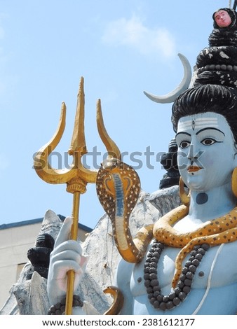 Closeup of beautiful hindu god Lord Shiva Statue at the top of the temple with snow background