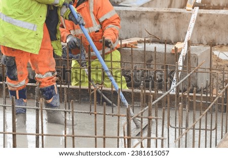 Concrete cast-in-place work. Builder level wet concrete. Concrete works on buildiiing construction site Royalty-Free Stock Photo #2381615057