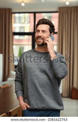 Handsome man talking on phone in cafe