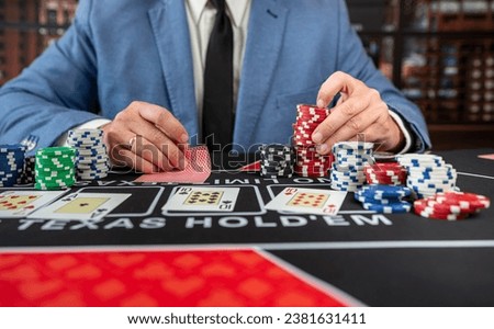 Gambler man hands pushing chips and going all-in in poker game at casino. Gambling entertainment concept  Royalty-Free Stock Photo #2381631411