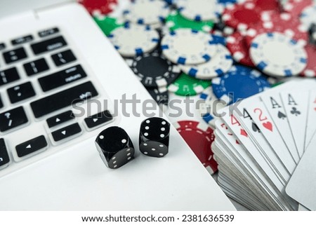 Online poker with laptop playing card chips and dice. Online gambling casino concept Royalty-Free Stock Photo #2381636539