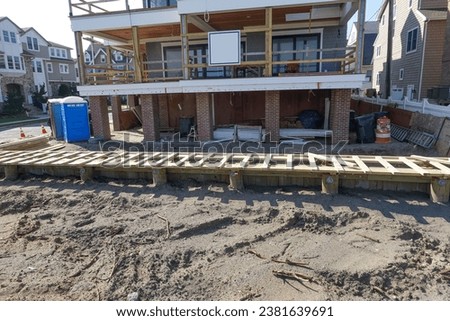 Elevated house on the sand by the boardwalk being renovated with added sea wall