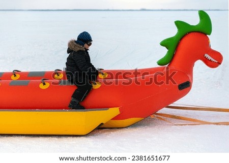 child boy riding on snow tubing. Winter joy and outdoor activity. natural light