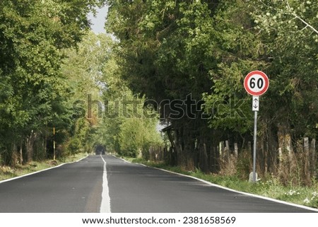 A road sign of speed limit of 60 against green grass