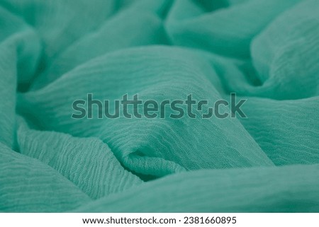 This is a high-resolution stock photo of a green-colored textured fabric background with soft, wavy lines