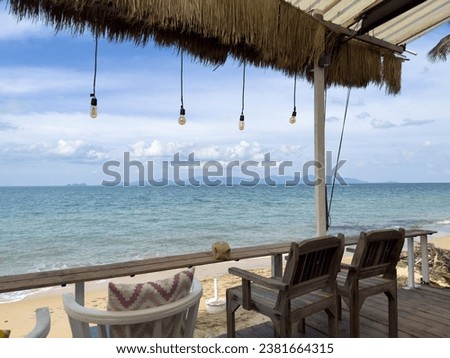 A picturesque outdoor scene with wooden chairs with a view of the ocean in the background