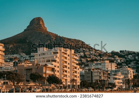 The buildings in Sea Point during sunset with the Lion's Head mountain peak in the background Royalty-Free Stock Photo #2381674827