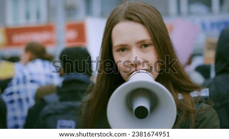 Young adult female feminist demonstration. Gender rights feminism fight. Women march movement power sign equality. Gender woman strike empowerment action. Social message. Crowd people city street day.