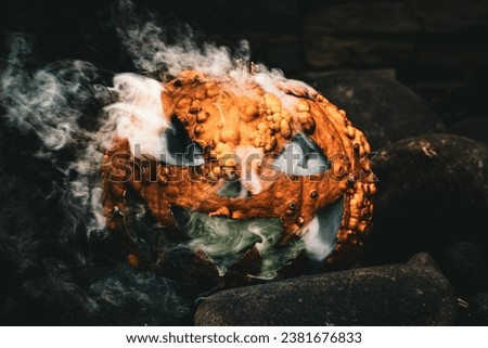 A closeup of smoke coming out from a spooky Halloween Jack o lantern on the stone