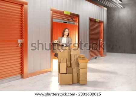 Woman near storage unit. Girl with cardboard boxes. Building with storage units for safekeeping. Woman brought things to warehouse. Storage unit rental concept. Warehouse with roller shutters Royalty-Free Stock Photo #2381680015