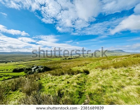 Landscape view towards Whernside on the Dales Way long distance walk in the Yorkshire Dales. Moorland in Ribblesdale on a bright sunny summer day. Royalty-Free Stock Photo #2381689839