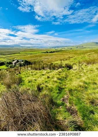 Vertical shot of Yorkshire landscape towards Whernside on the Dales Way long distance walk in the Yorkshire Dales. Moorland in Ribblesdale on a bright sunny summer day. Royalty-Free Stock Photo #2381690887