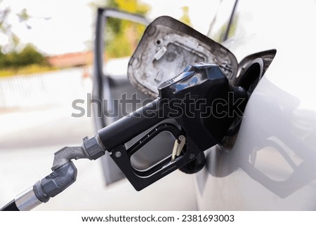 gas station scene with a rusted oil pump, under a setting sun, highlighting pricing, inflation, and rising fuel costs, evoking nostalgia and economic challenges