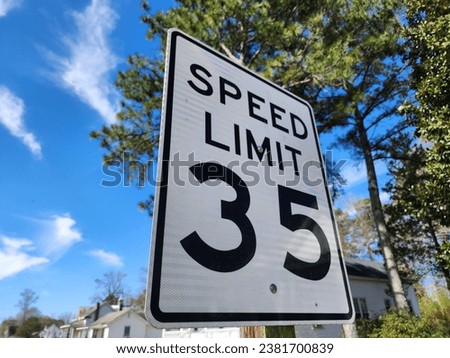 A closeup of 35 speed limit road sign under the blue sky with a blurry background