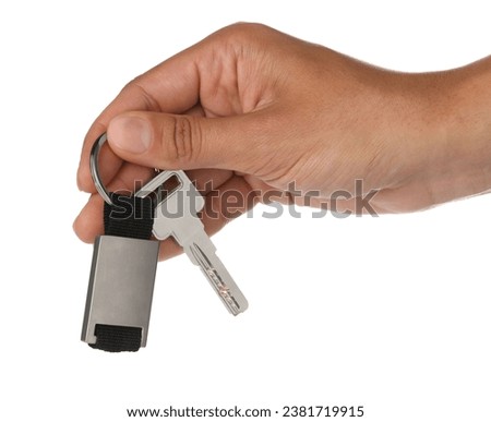 Woman holding key with metallic keychain on white background, closeup