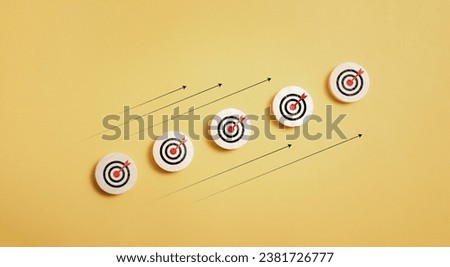 wooden block with target icon and arrow aim to target on orange background for business achievement goal and objective target concept.