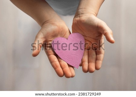 love and kindness, child hands holding paper heart, affection, bonding and care concept Royalty-Free Stock Photo #2381729249
