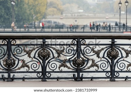Paris, France. Railing of the Notre Dame bridge that passes over the River Seine on an autumn afternoon. Selective focus.