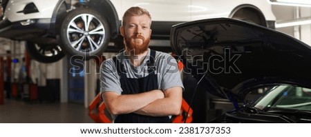 Portrait of a professional car mechanic in a clean uniform against the background of a modern car repair center. Panoramic photography