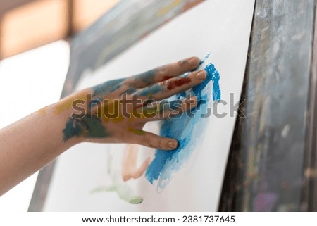 finger painting, young female artist drawing a picture with her hands